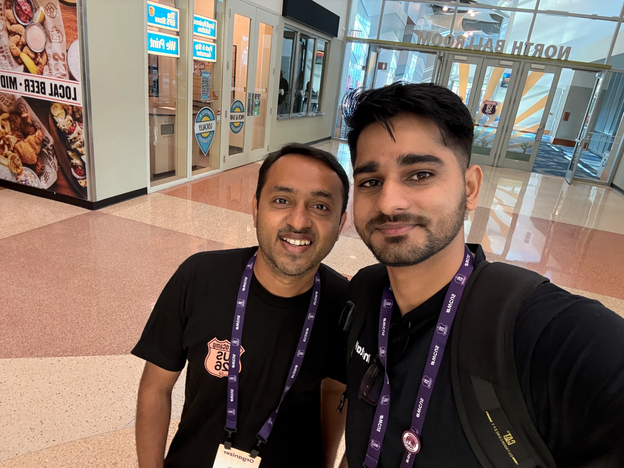 Ananta taking a hallway selfie with an event organizer in the North Ballroom corridor